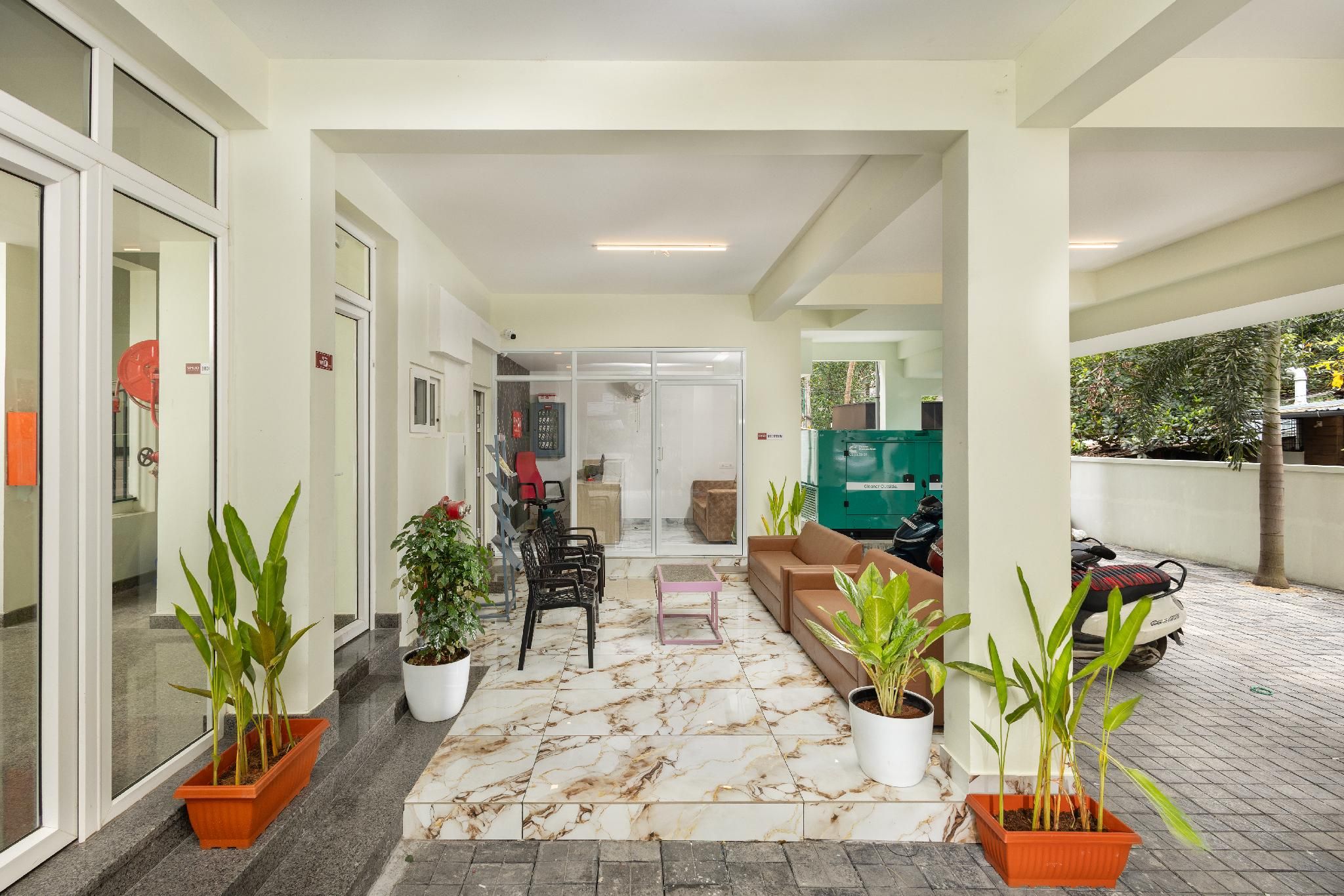 A reception area with a seating arrangement, potted plants, and a view of the outside.