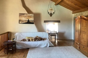 A cozy room with a bed, a wooden cabinet, a painting, and a hanging light fixture. - Holiday home with 2 bedrooms (Lagorce, Ardèche)