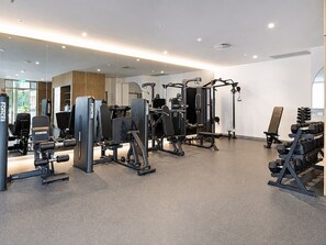 A modern gym with various exercise equipment, including weight machines and free weights. - Sky High at Sunrise - Lagoon Main Beach (Main Beach)
