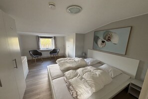 Ein modernes Schlafzimmer mit einem großen Bett, einem Schreibtisch und einem Stuhl.