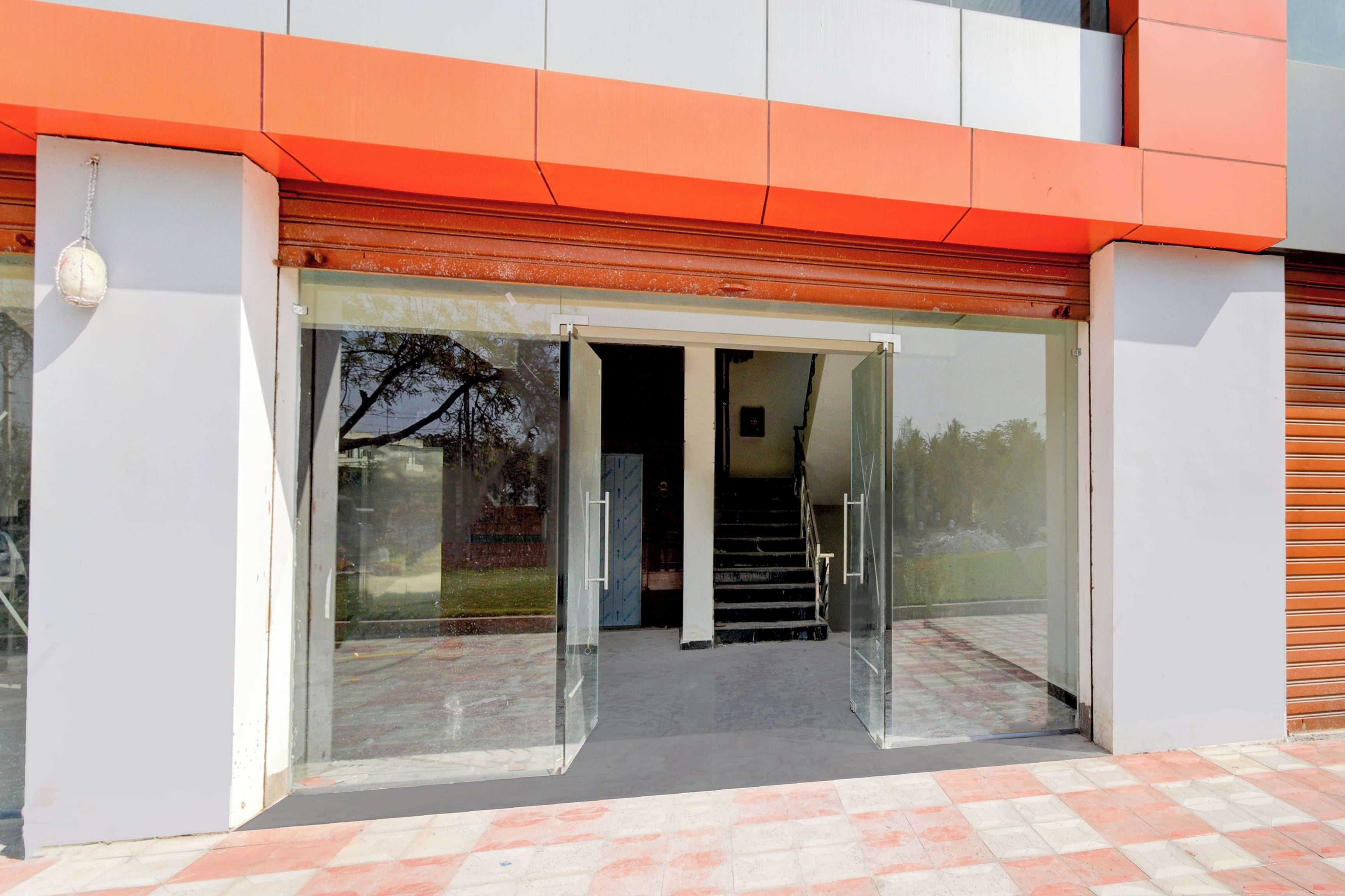 A building entrance with a glass door and a staircase leading inside.