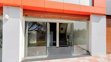 A building entrance with a glass door and a staircase leading inside.