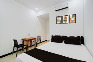 A hotel room with a bed, a desk, two chairs, and three wall-mounted artworks. - Hotel O P3 Thumkunta (Shamirpet)