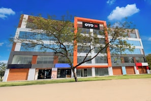 Un edificio moderno con un letrero llamativo de OYO.
