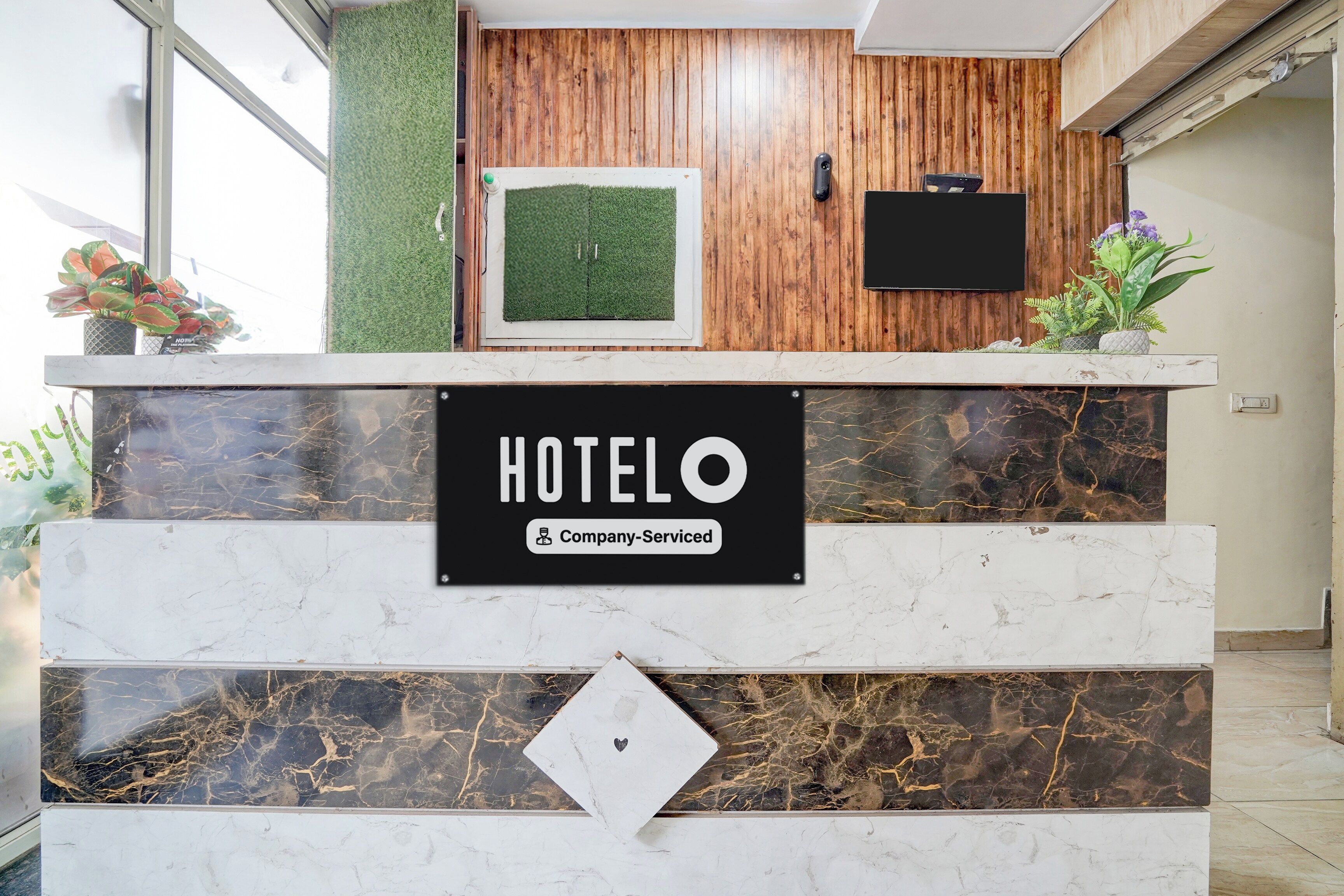 Un mostrador de recepción de hotel con un cartel que indica que es un hotel de servicio empresarial.