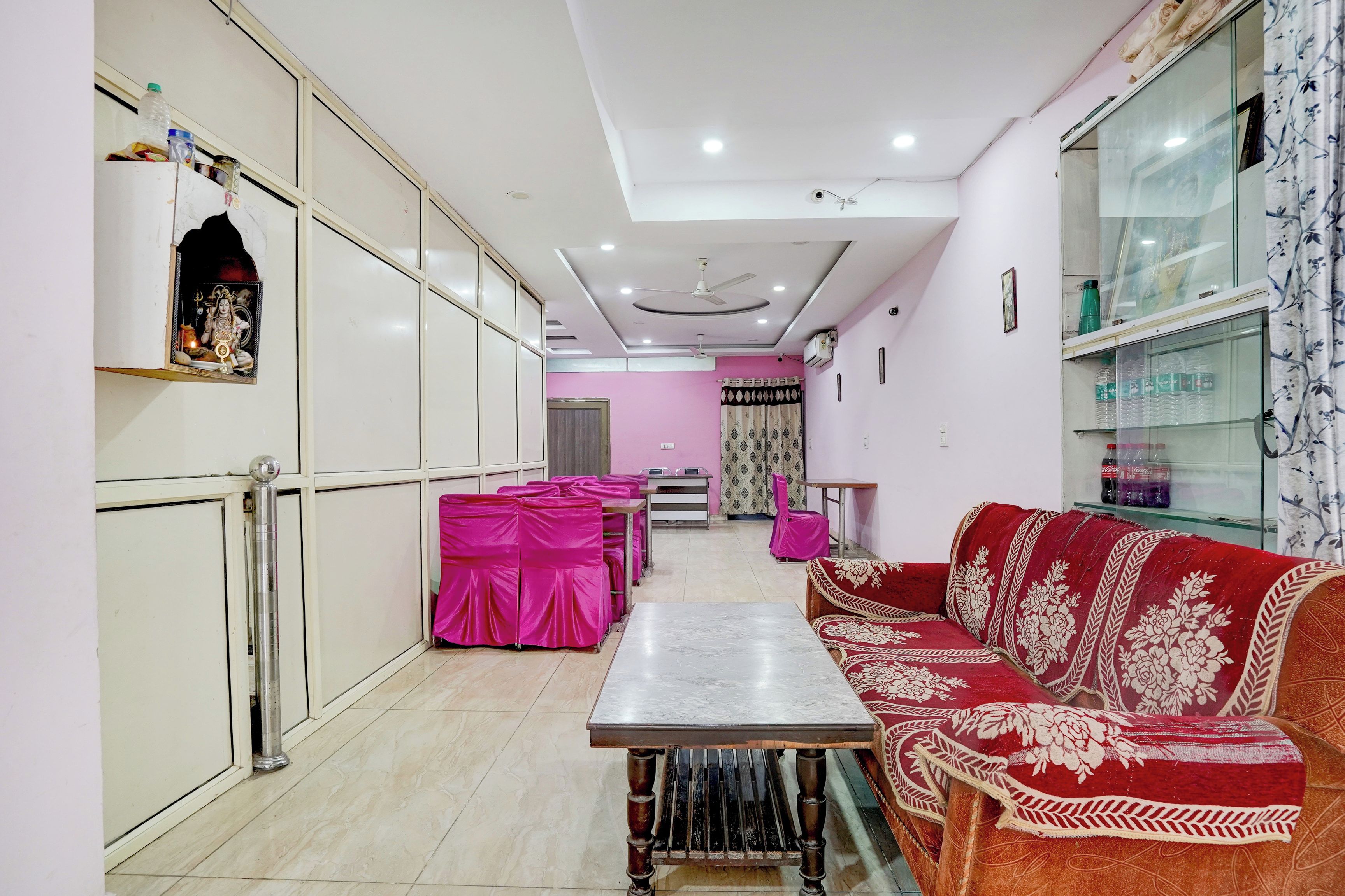 Una habitación con un sofá, una mesa y un mantel rosa.