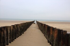A beach with a wooden walkway leading to the sea. - Holiday apartment with 1 bedroom (Zoutelande)