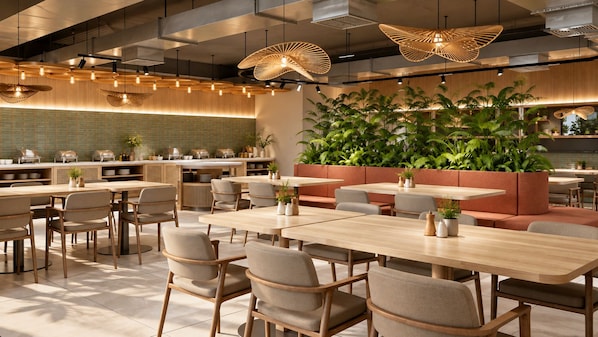 A modern restaurant with wooden tables and chairs, hanging rattan lamps, and a green wall with plants.