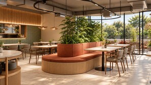 A modern restaurant interior with a central seating area, tables, and hanging lights.