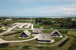 Un quartier résidentiel avec des maisons modernes, un parking et une vue sur la mer.