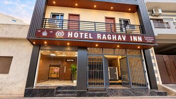 A hotel with a reception area, a balcony, and a sign indicating room availability.