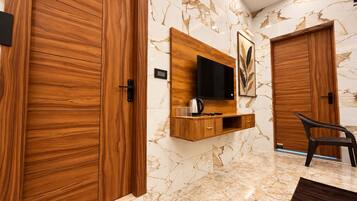 A modern interior with wooden doors, a mounted TV, and a seating area.