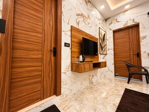 Un interior moderno con puertas de madera, un televisor montado y una zona de estar.