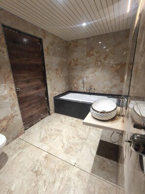 A modern bathroom with a marble floor, a bathtub, a large mirror, and a wooden door. - Beautiful 3-bedroom bungalow with AC in serene Panchgani (Panchgani, Satara)