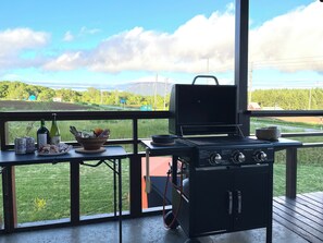 A barbecue grill on a deck with a view of a green landscape and a mountain in the distance. - Mountain View Niseko 【Private Cottage with Great Views】 (ニセコ町)