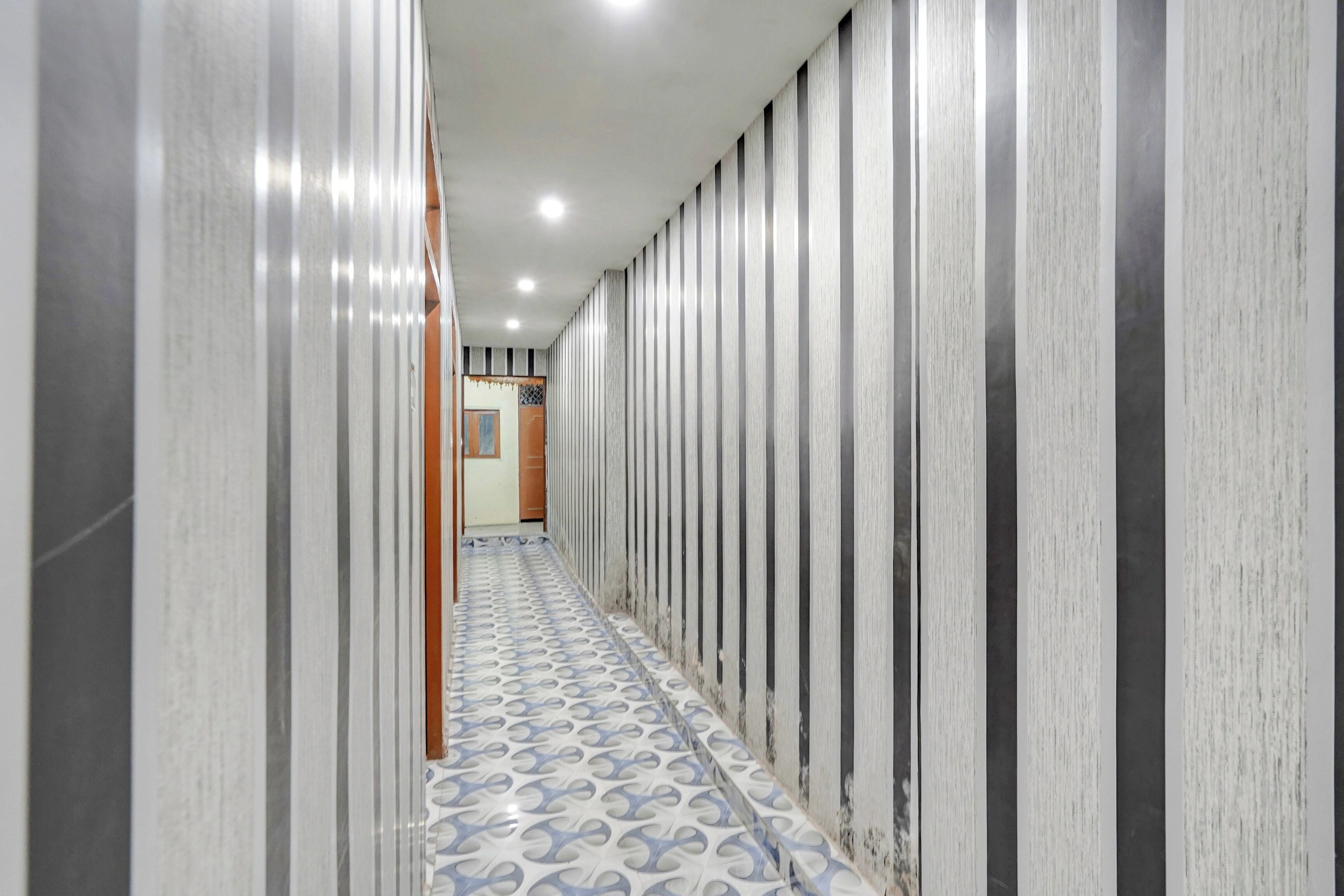 Un pasillo con suelo estampado y paneles verticales en la pared.