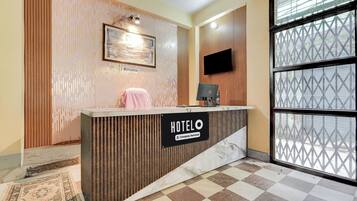 A hotel reception desk with a sign indicating it's a company-serviced hotel.