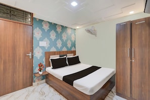 Un dormitorio con cama, mesita de noche, ventilador de pared y armario.