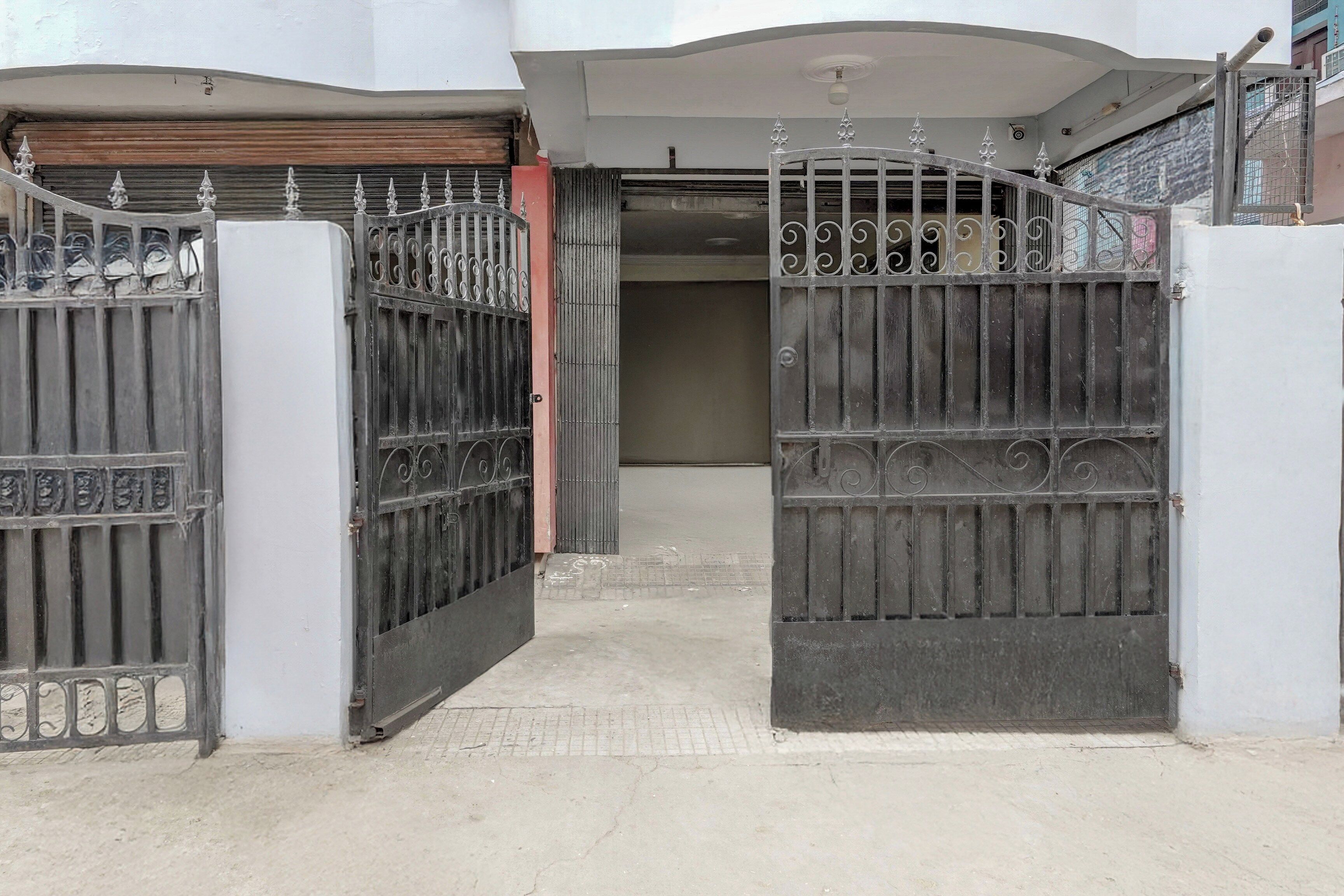 A gated entrance to a building with a closed garage door and a metal gate with decorative elements.