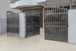 Una entrada protegida con una reja metálica y una puerta cerrada.