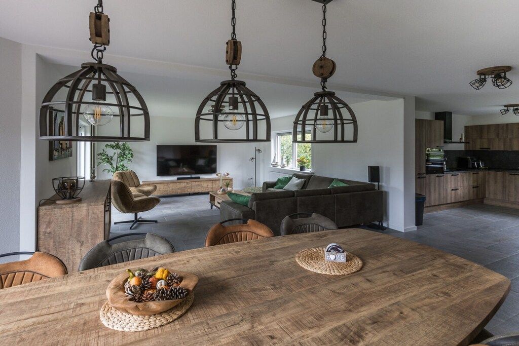 Una sala moderna con una mesa de comedor de madera, un sofá y un televisor.