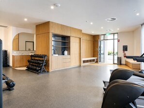 A modern reception area with a reception desk, seating, and a counter with a mirror. - Elevated Escape at Sunrise - Lagoon Main Beach (Main Beach)