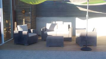 Un espace extérieur aménagé avec des meubles en osier et une piscine.