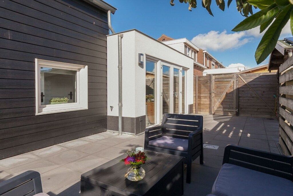 A patio with a table, chairs, and a flower arrangement.