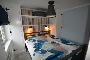 A bedroom with a bunk bed, a ceiling lamp, and a wall-mounted shelf. - Noordkerkepad Westkapelle (Westkapelle)