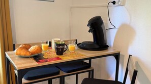 Ein Frühstücksarrangement mit Croissants, einer Kaffeetasse und zwei Gläsern Orangensaft auf einem Holztisch.