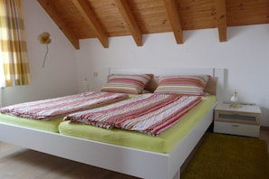 A bedroom with a bed, bedside tables, and a window with curtains. - Holiday apartment with 2 bedrooms (Langenargen)