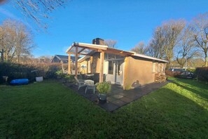 A house with a patio, a covered outdoor area, and a brick exterior. - Holiday home with flair in Holland (Andijk)