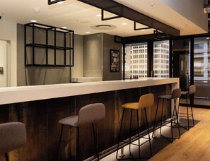 A modern bar area with a long counter and multiple stools. - Cozy 1-bedroom apartment in phenomenal Cape Town with AC (Cape Town)
