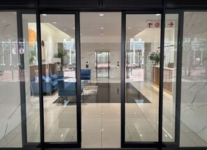 A modern lobby with a glass entrance, a reception desk, and a seating area with sofas. - Cozy 1-bedroom apartment in phenomenal Cape Town with AC (Cape Town)