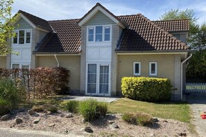 A two-story house with a tiled roof, a front porch, and a well-maintained garden. - Lieblingsplatz de Banjaard (Kamperland)