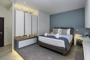 A modern bedroom with a bed, bedside tables, and a built-in wardrobe. - Amara Solar Living Partial Sea View Apartment (Agia Marina)
