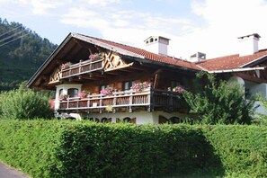 A traditional chalet with a balcony, surrounded by greenery. - Holiday apartment with 2 bedrooms (Wallgau)