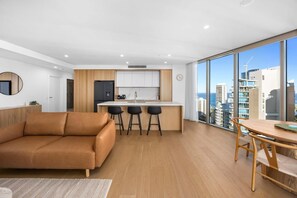 Eine moderne Wohnung mit Küche, Essbereich und großen Fenstern mit Blick auf die Stadt.