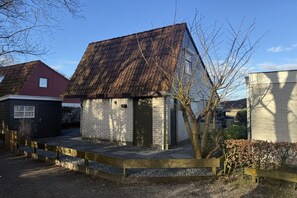 Un petit bâtiment d’un seul étage, doté d’un toit en pente, d’une façade en briques et d’un petit porche.