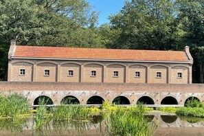 Ein Backsteinhaus mit rotem Ziegeldach und mehreren Rundbögen.