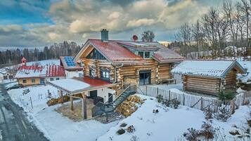 Eine Holzhütte mit rotem Dach, einer Veranda und einer Treppe zum Eingang.