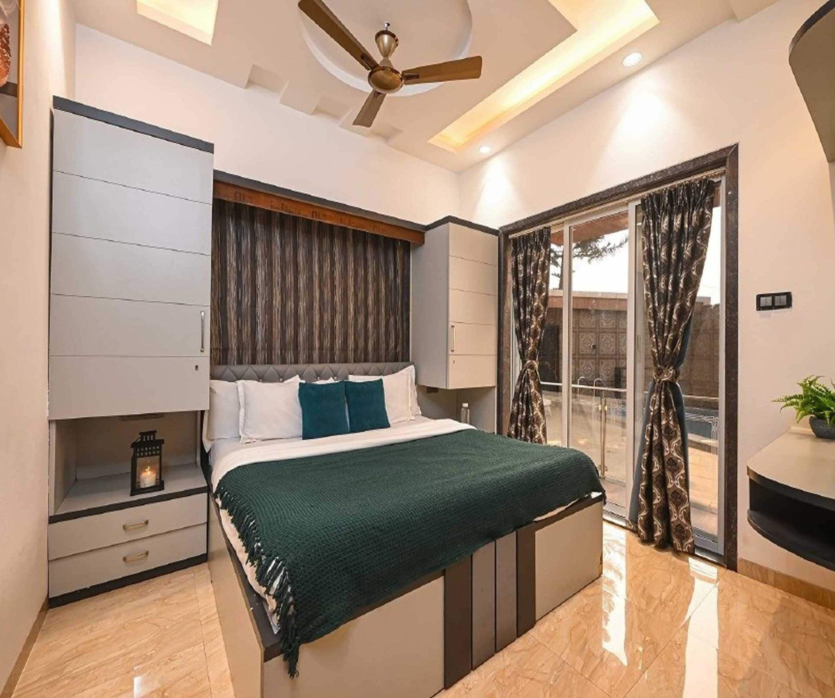 A modern bedroom with a bed, a ceiling fan, a nightstand, and a sliding glass door leading to an outdoor area.