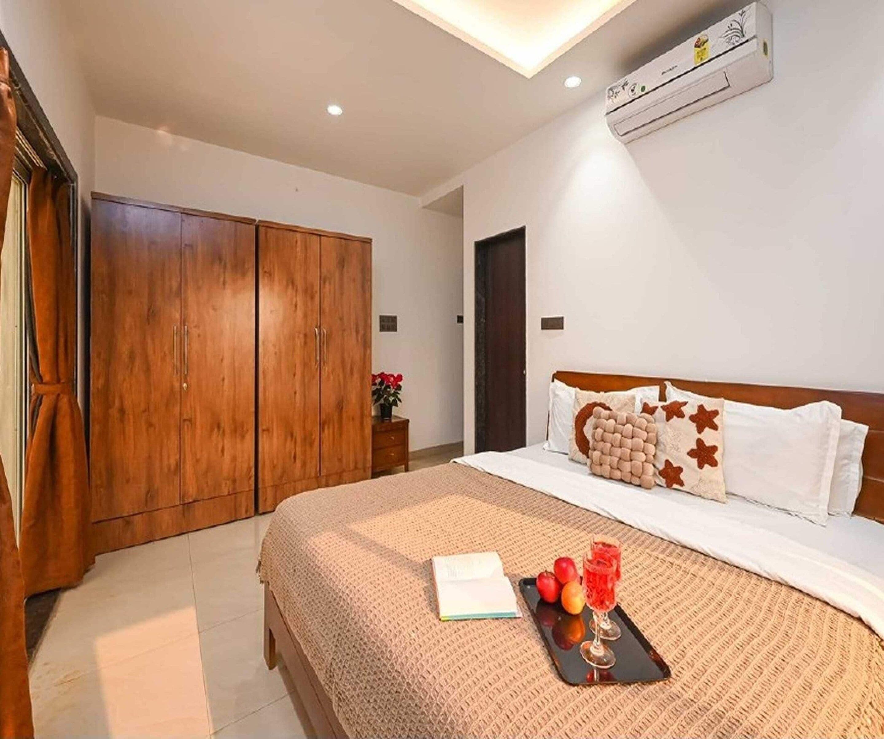 Ein Hotelzimmer mit Bett, Kleiderschrank, Nachttisch und Klimaanlage.