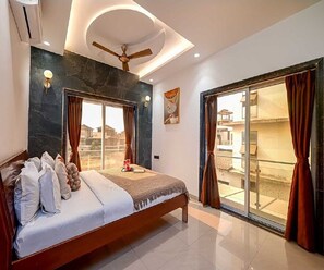 Un dormitorio con cama, cortinas, ventilador de techo y vistas a través de un ventanal corredero.