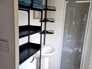 A bathroom with a white sink, black shelves, and a towel rack. - Beach Resort Kamperland - 167 (Kamperland)