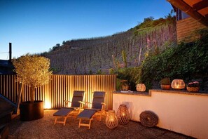 A patio area with lounge chairs, a potted tree, and decorative lanterns. - Old wine press house (Bernkastel-Kues)