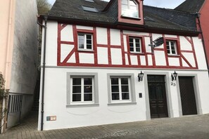 A traditional half-timbered building with a black door and numbered windows. - Old wine press house (Bernkastel-Kues)