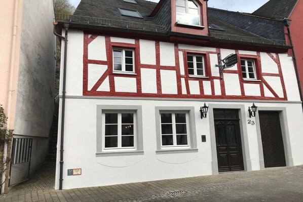 A traditional half-timbered building with a black door and numbered windows. - Old wine press house (Bernkastel-Kues)