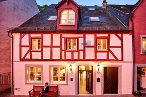 A traditional half-timbered building with a dark roof, a red door, and a number '23' sign. - Old wine press house (Bernkastel-Kues)