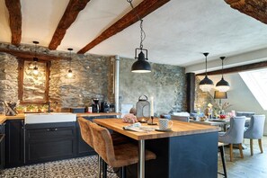 A rustic kitchen with stone walls, wooden beams, and pendant lighting. - Old wine press house (Bernkastel-Kues)